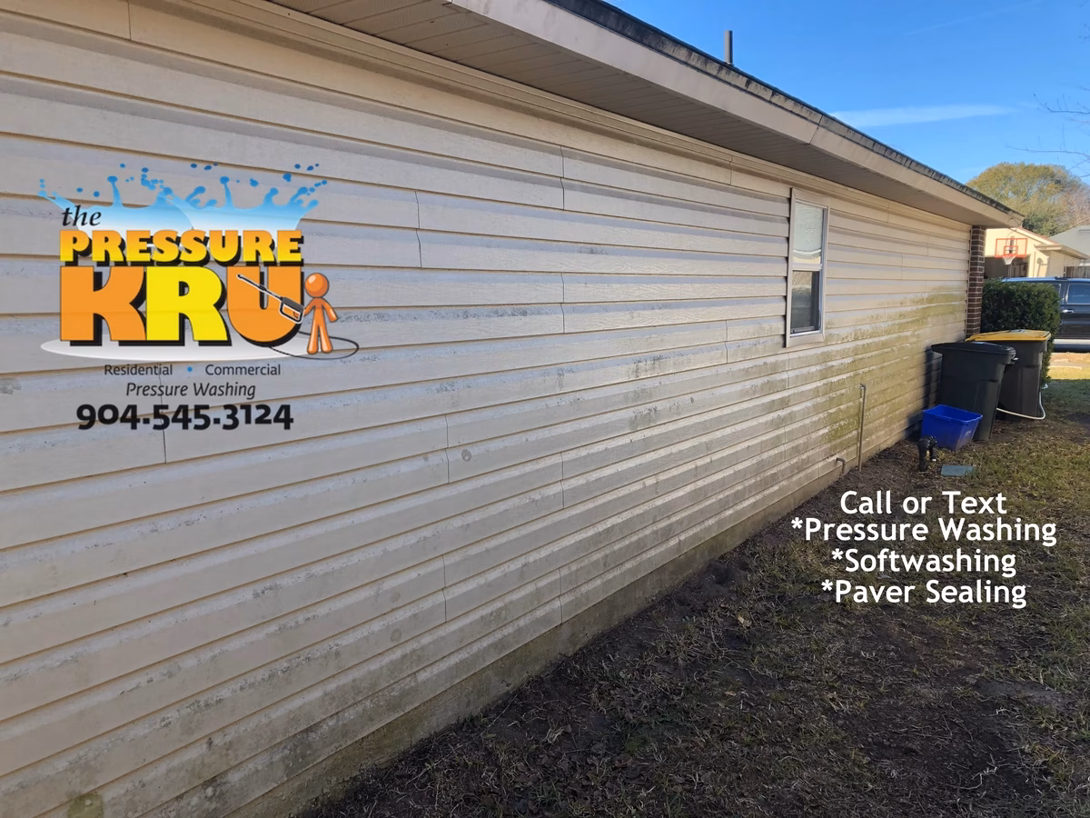 Soft Washing vinyl siding before removing green mold and algae in Bartram area.