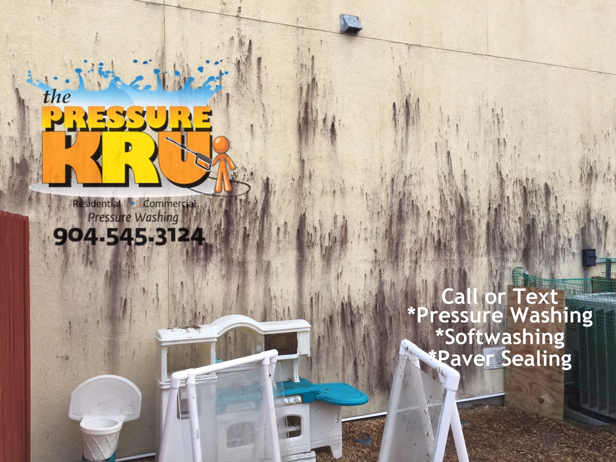 Stucco daycare building receiving professional soft washing treatment in St Johns FL before cleaning.