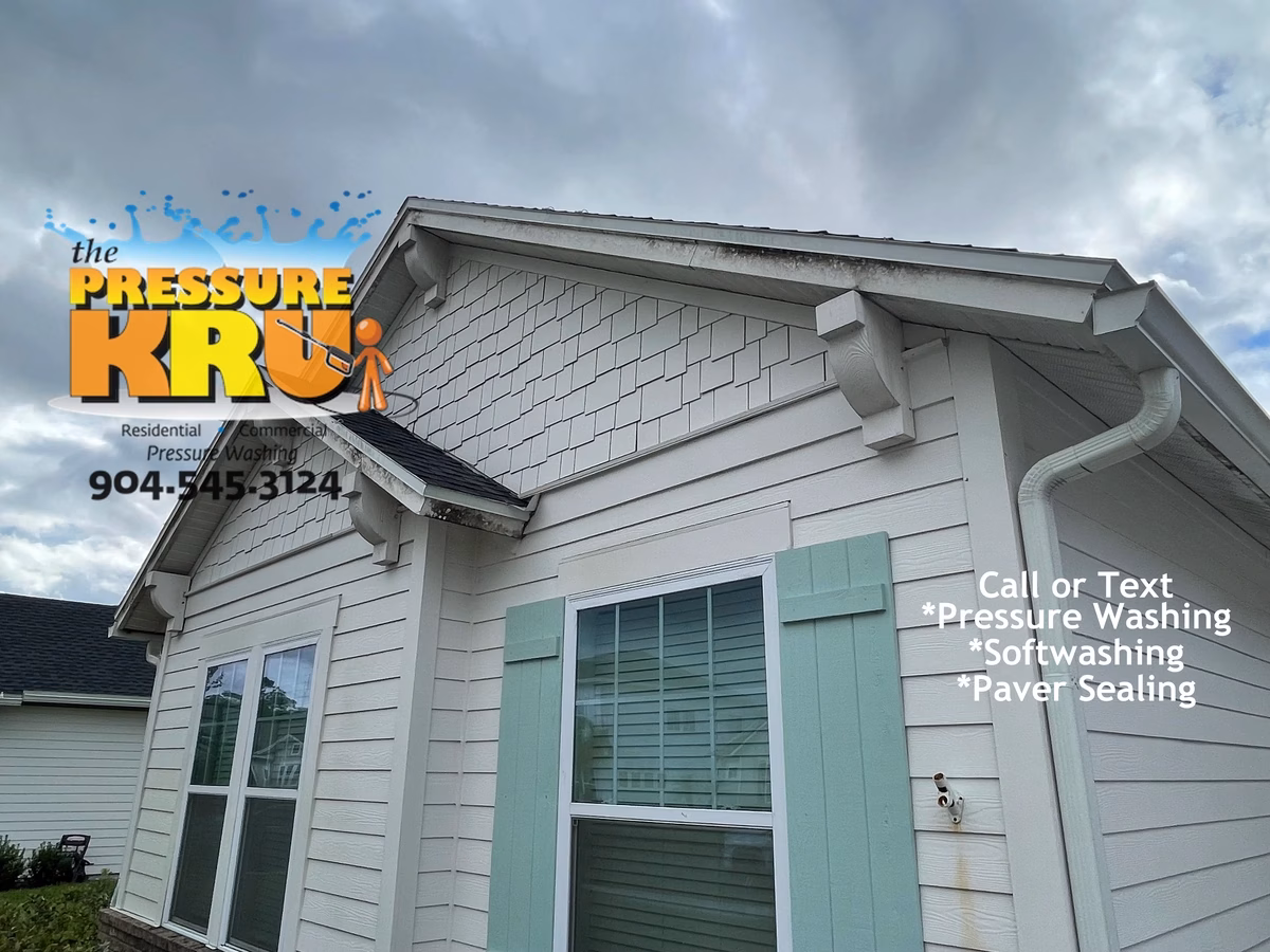 Professional house washing removes algae from siding and concrete in Rivertown neighborhood.
