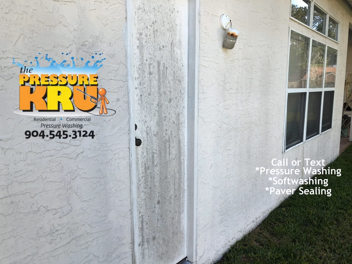 Removing black streaks from a stucco home before soft washing in St Johns Golf and Country Club.