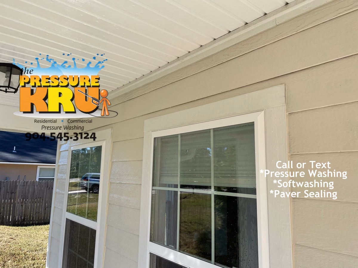 Softwashing home exterior in Julington Creek Neighborhood removing years of organic growth.