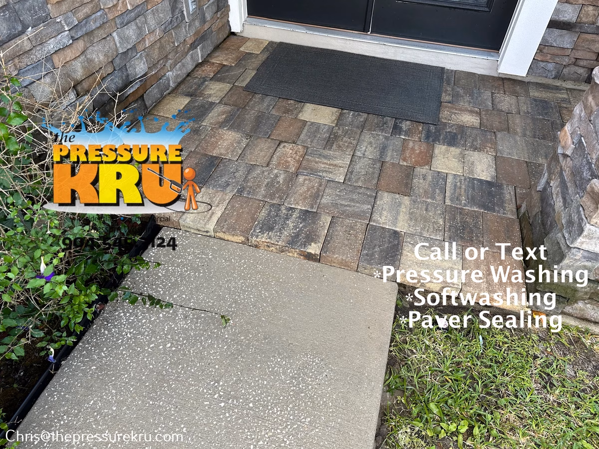 Removing dirt, moss, and weeds from paver driveway after pressure washing in Durbin Crossing.