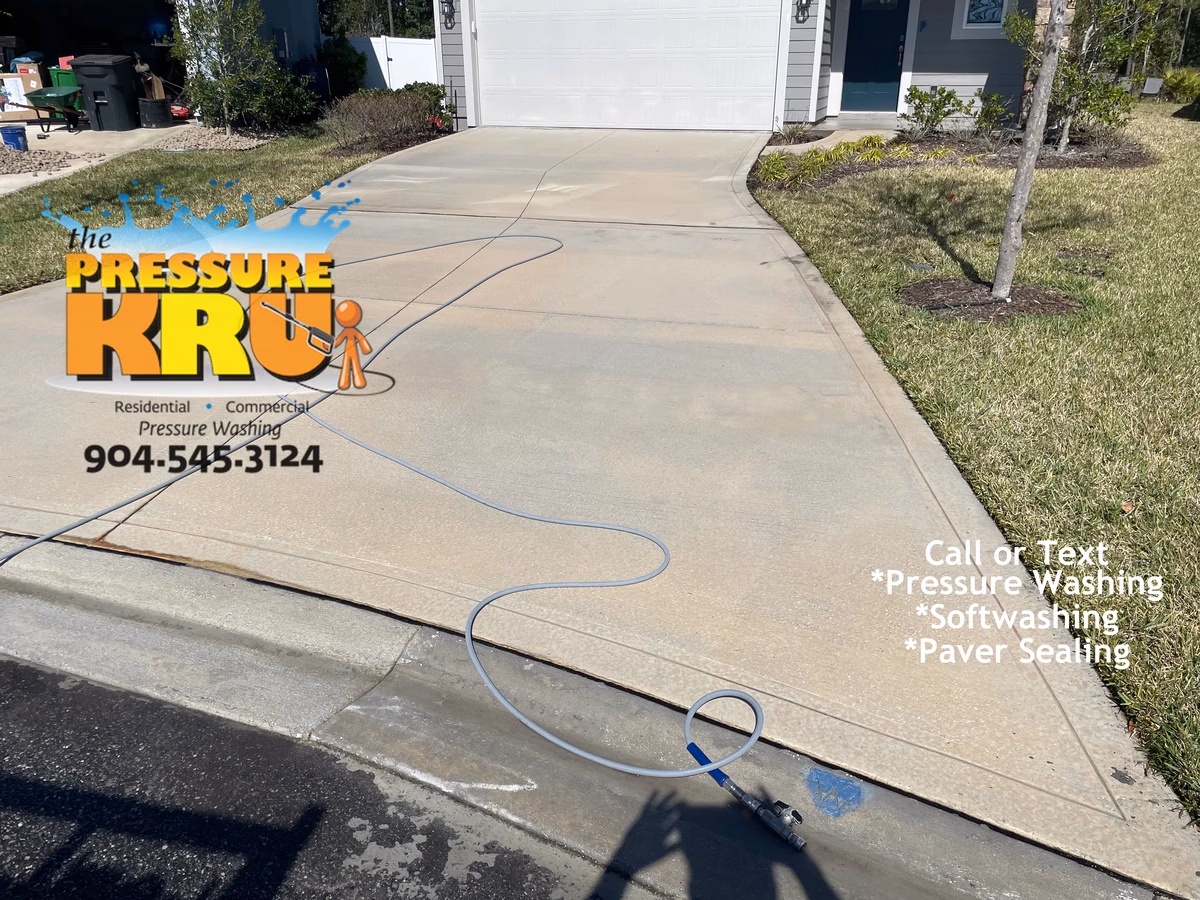 Professional pressure washing driveway before and after in St. Johns, FL. After annual cleaning showing difference cleaning makes.