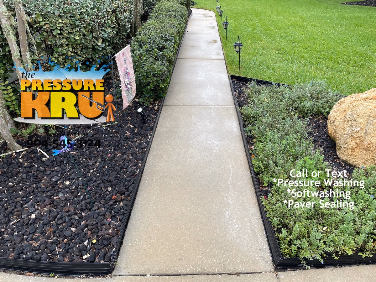 Clean driveway and sidewalk contrasting with fresh lawn and landscaping in St. Johns, FL. After Picture.