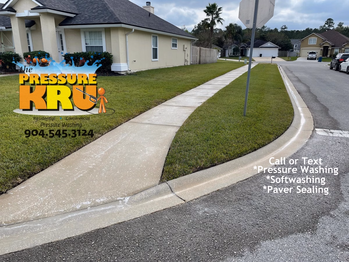 Before and after comparison of pressure washed concrete sidewalk and driveway in Fruit Cove, FL After pressure washing and soft washing.