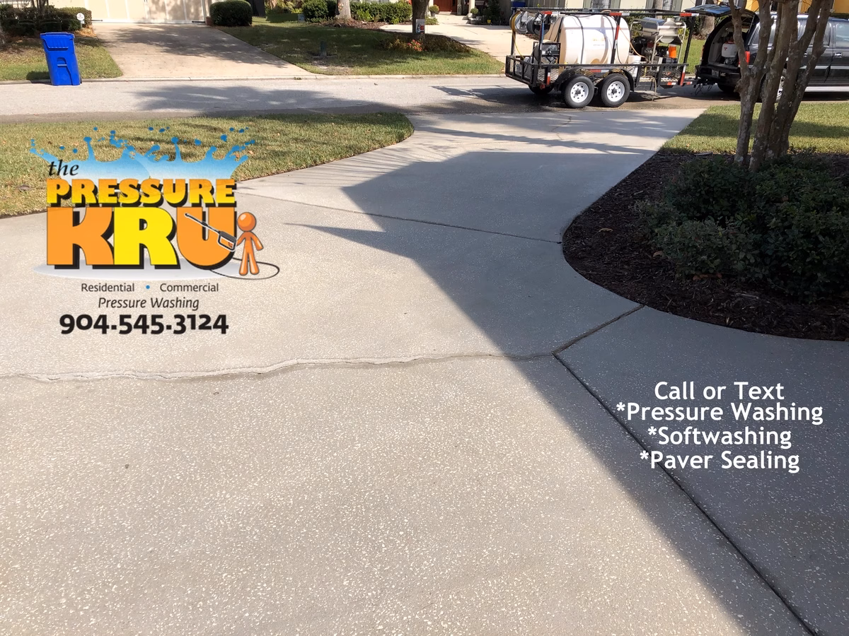 Concrete driveway power washing removing fall and winter grime in St Johns FL after cleaning.