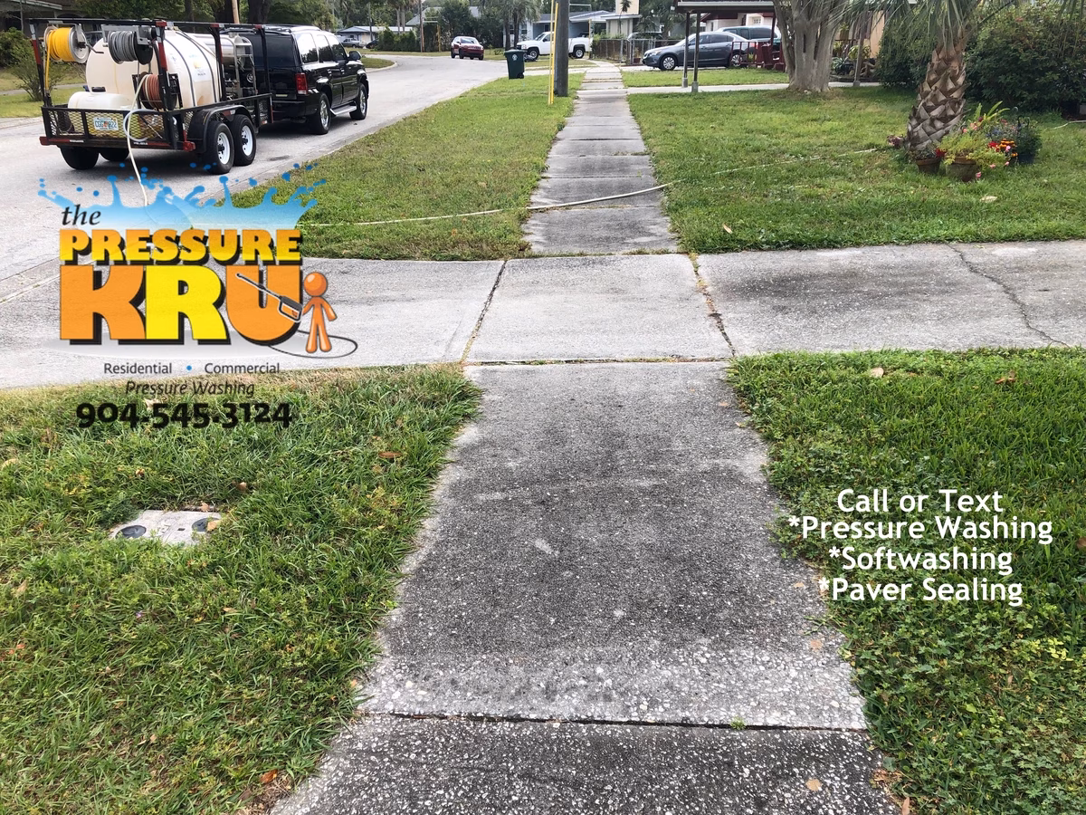 Professional power washing team cleaning residential driveway near me in St. Augustine, FL. Before service.