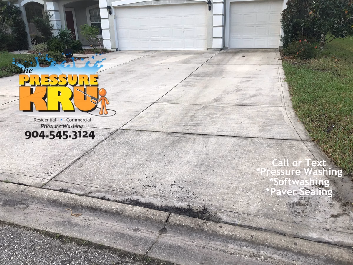 Local driveway cleaning company restoring curb appeal with soft wash chemicals in St. Johns, FL before.