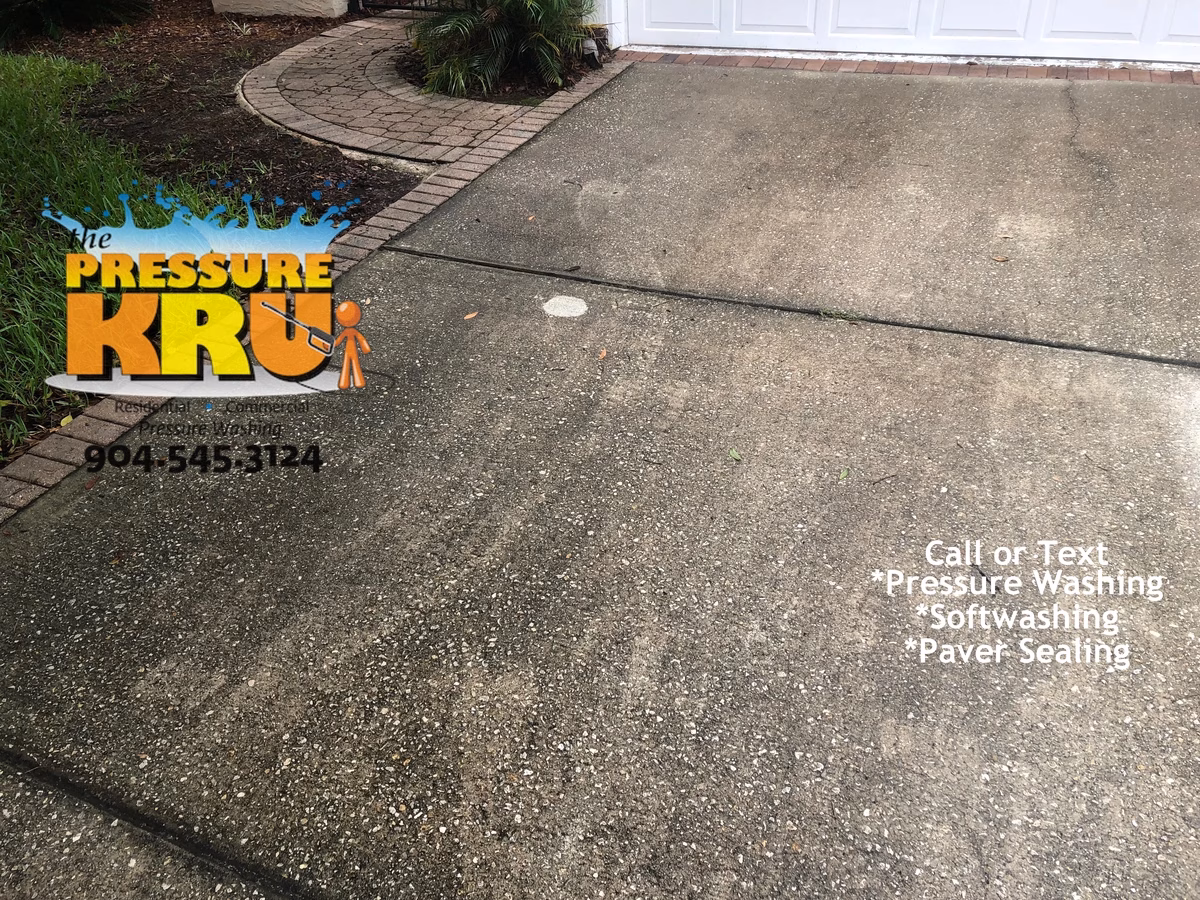 Pressure washing driveway before softwashing in Jacksonville, FL.