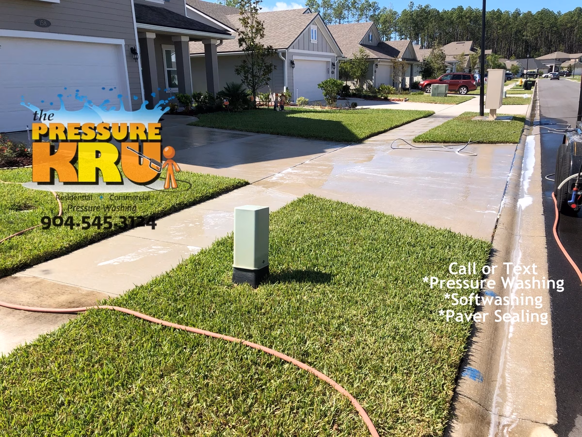Pressure washing concrete driveway to remove organic staining in Fruit Cove, FL. After picture.