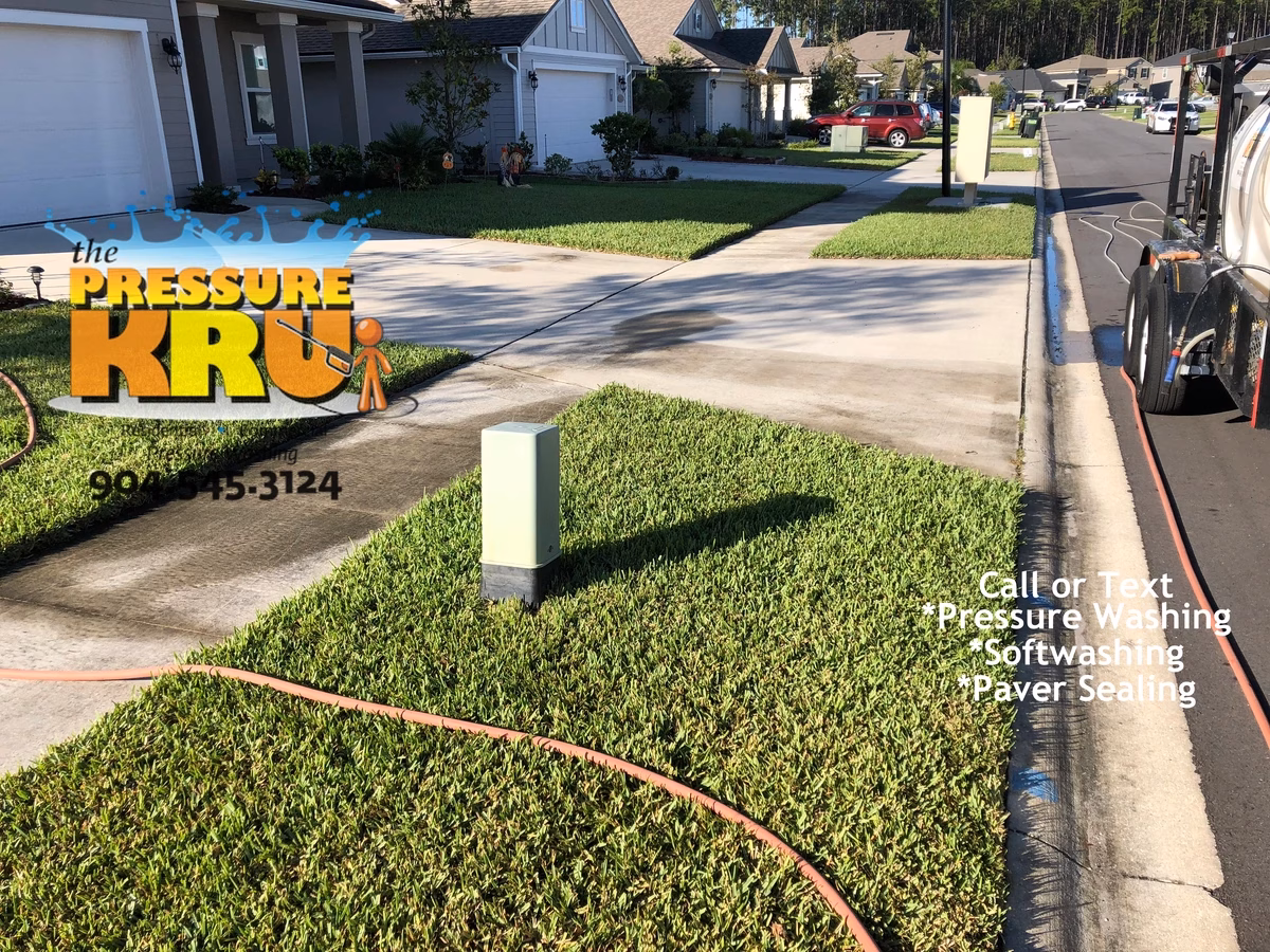 Pressure washing concrete driveway to remove organic staining in Fruit Cove, FL. Before picture.