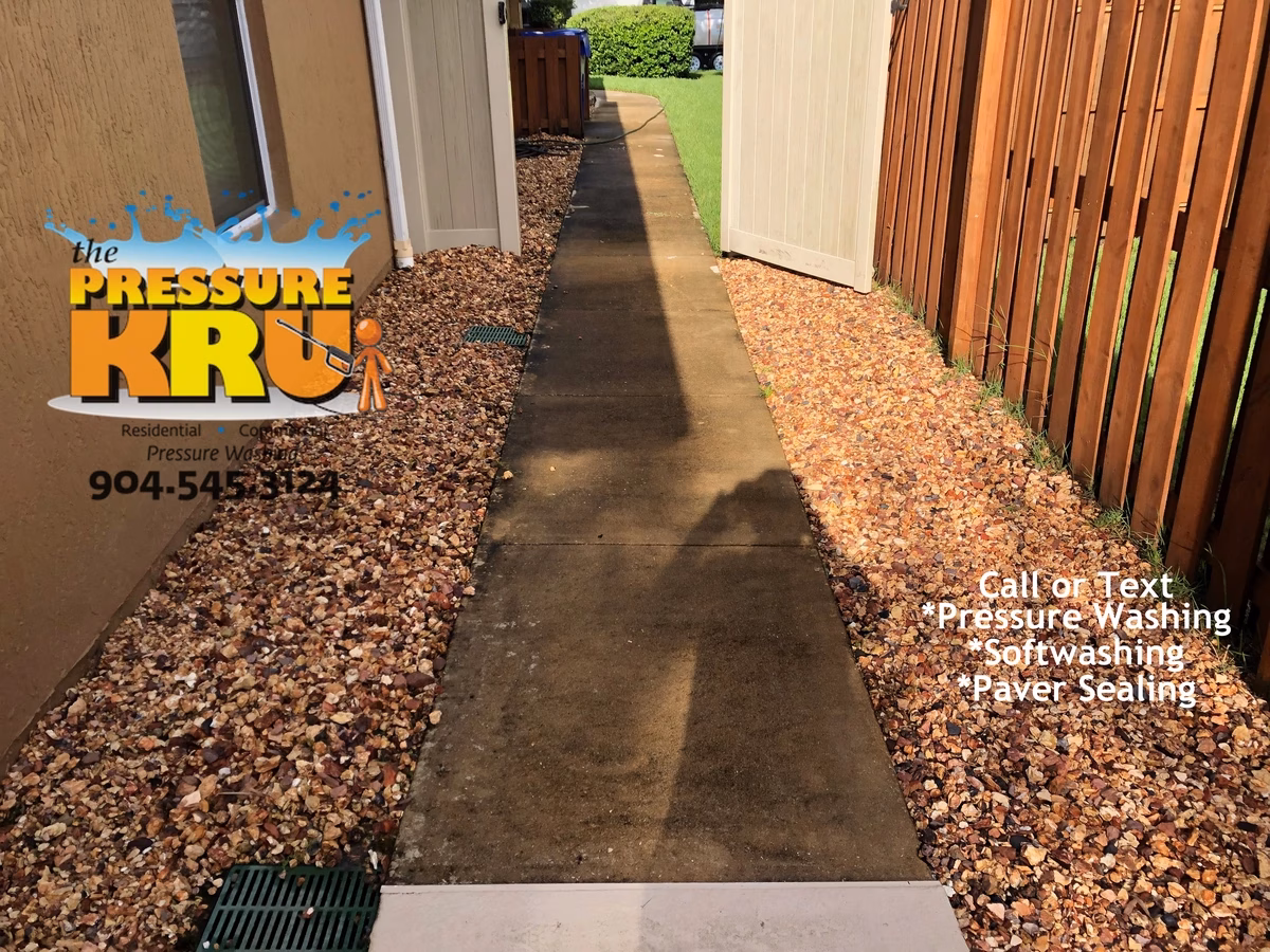 Driveway and sidewalk pressure washing service in St. Johns, FL before chemical treatment.