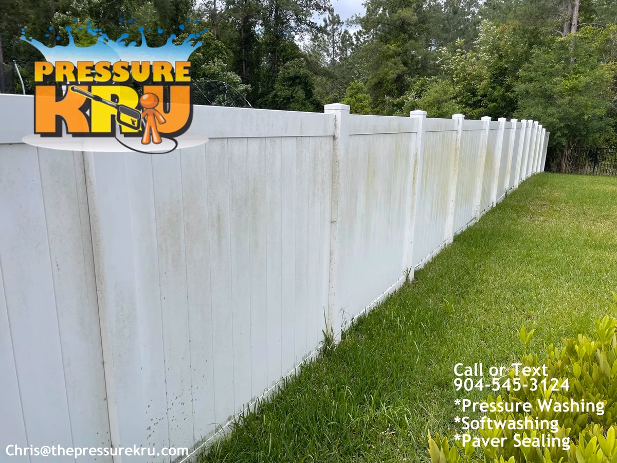 White vinyl fence cleaning before pressure washing in Orange Park Country Club showing green algae